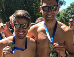 Zwei Läufer halten Medaille in die Kamera