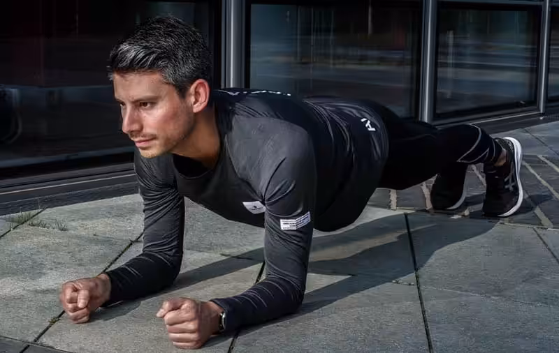 Läufer macht eine Plank im Rahmen von Kraft- und Stabitraining.
