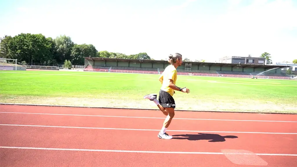 Läufer führt Anfersenauf der Laufbahn durch – die linke Ferse geht aktiv zum Gesäß