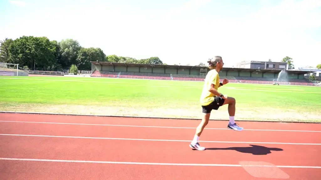 Läufer führt den B-Skip auf der Laufbahn durch – das rechte Bein ist angewinkelt, kurz bevor der Läufer das Bein nach vorne ausstreckt