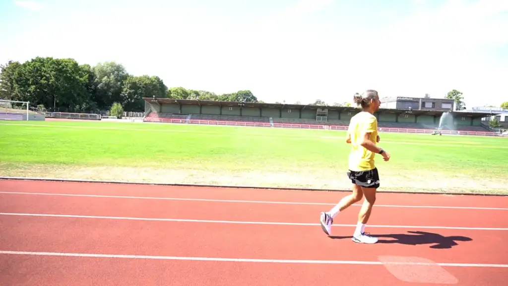 Läufer führt den B-Skip auf der Laufbahn durch – der rechte Fuß steht senkrecht unter dem Körper auf dem Boden