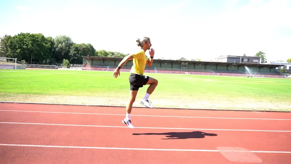 Läufer führt Hopserlauf auf der Laufbahn durch – beide Beine sind in der Luft, das rechte Bein ist angewinkelt. Der Abdruck kam aus dem linken Fuß