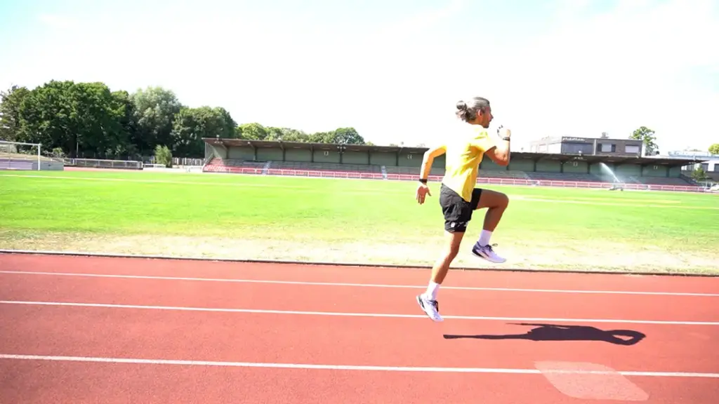 Läufer führt Hopserlauf auf der Laufbahn durch – beide Beine sind in der Luft, das linke Bein ist angewinkelt. Der Abdruck kam aus dem rechten Fuß