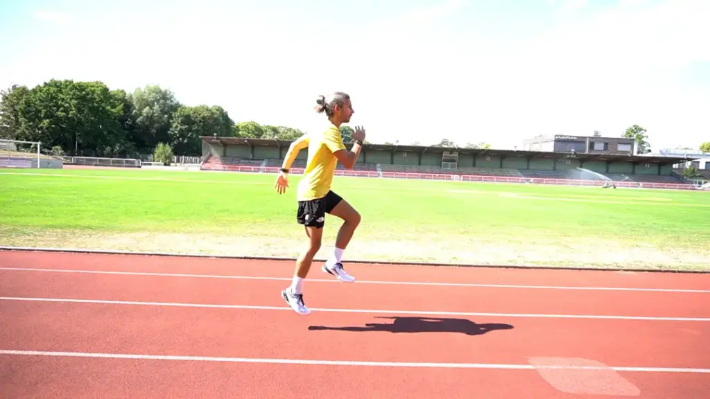 Läufer führt Prellhopser auf der Laufbahn durch – beide Beine sind in der Luft, das linke Bein ist angewinkelt. Der Abdruck kam aus dem rechten Fuß
