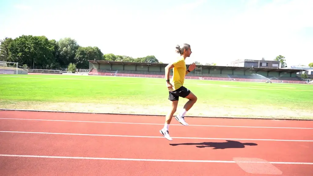 Läufer führt Prellhopser auf der Laufbahn durch – beide Beine sind in der Luft, das rechte Bein ist angewinkelt. Der Abdruck kam aus dem linken Fuß