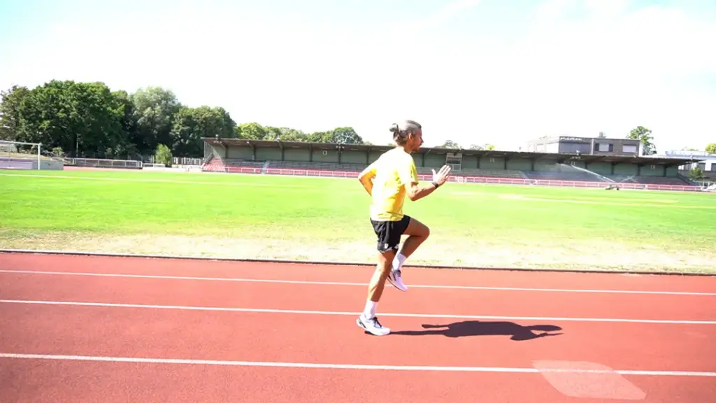 Läufer führt Skippings auf der Laufbahn durch – das linke Knie wird gerade angehoben