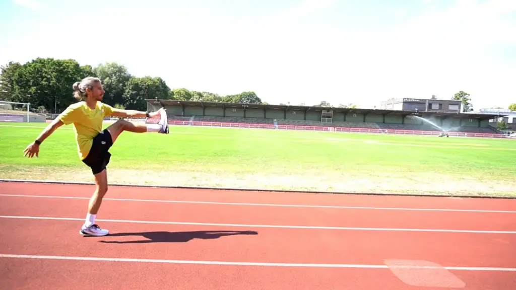 Läufer führt den Soldatenschritt auf der Laufbahn mit dem rechten Bein durch
