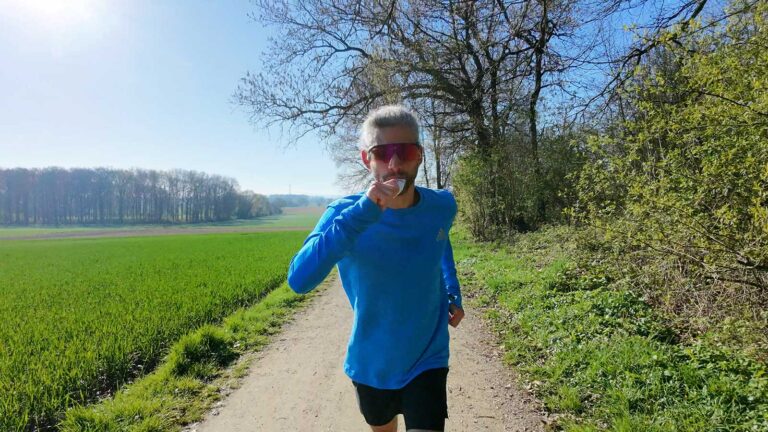 Essen beim Laufen: Läufer nimmt Gel während eines Trainingslaufs