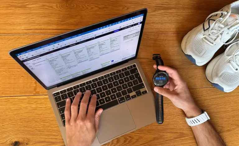 Lauftraining strukturiert aufbauen: TrainingPeaks-Wochenplan auf dem Laptop und eine Garmin-Laufuhr mit Intervall-Workout daneben